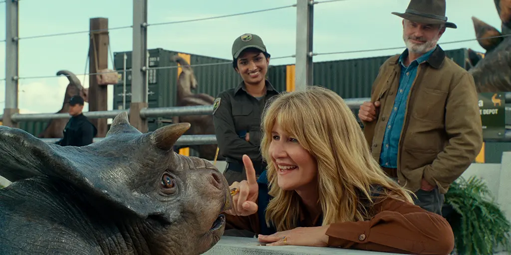 (from left) A baby Nasutoceratops, Dr. Ellie Sattler (Laura Dern) and Dr. Alan Grant (Sam Neill) in Jurassic World Dominion, co-written and directed by Colin Trevorrow - © 2022 Universal Studios and Amblin Entertainment. All Rights Reserved