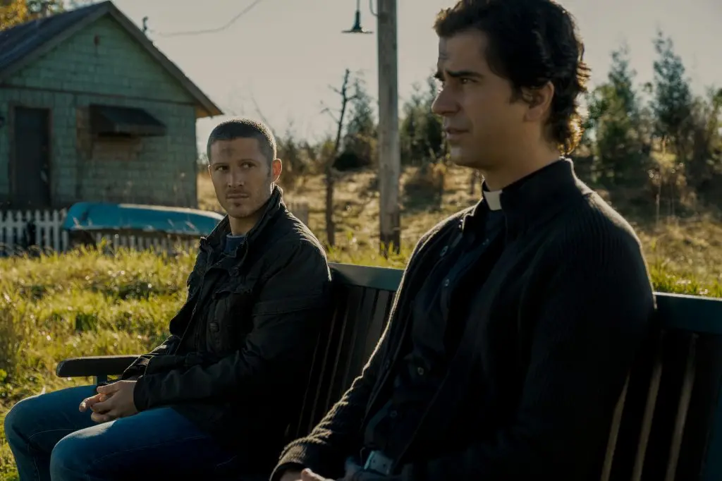 MIDNIGHT MASS (L to R) ZACH GILFORD as RILEY FLYNN and HAMISH LINKLATER as FATHER PAUL in episode 102 of MIDNIGHT MASS Cr. EIKE SCHROTER/NETFLIX \\u00A9 2021