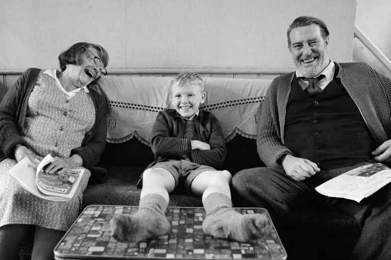 (L to R) Judi Dench as \"Granny\", Jude Hill as \"Buddy\" and Ciar\\u00E1n Hinds as \"Pop\" in director Kenneth Branagh\\'s BELFAST, a Focus Features release. Credit : Rob Youngson / Focus Features
