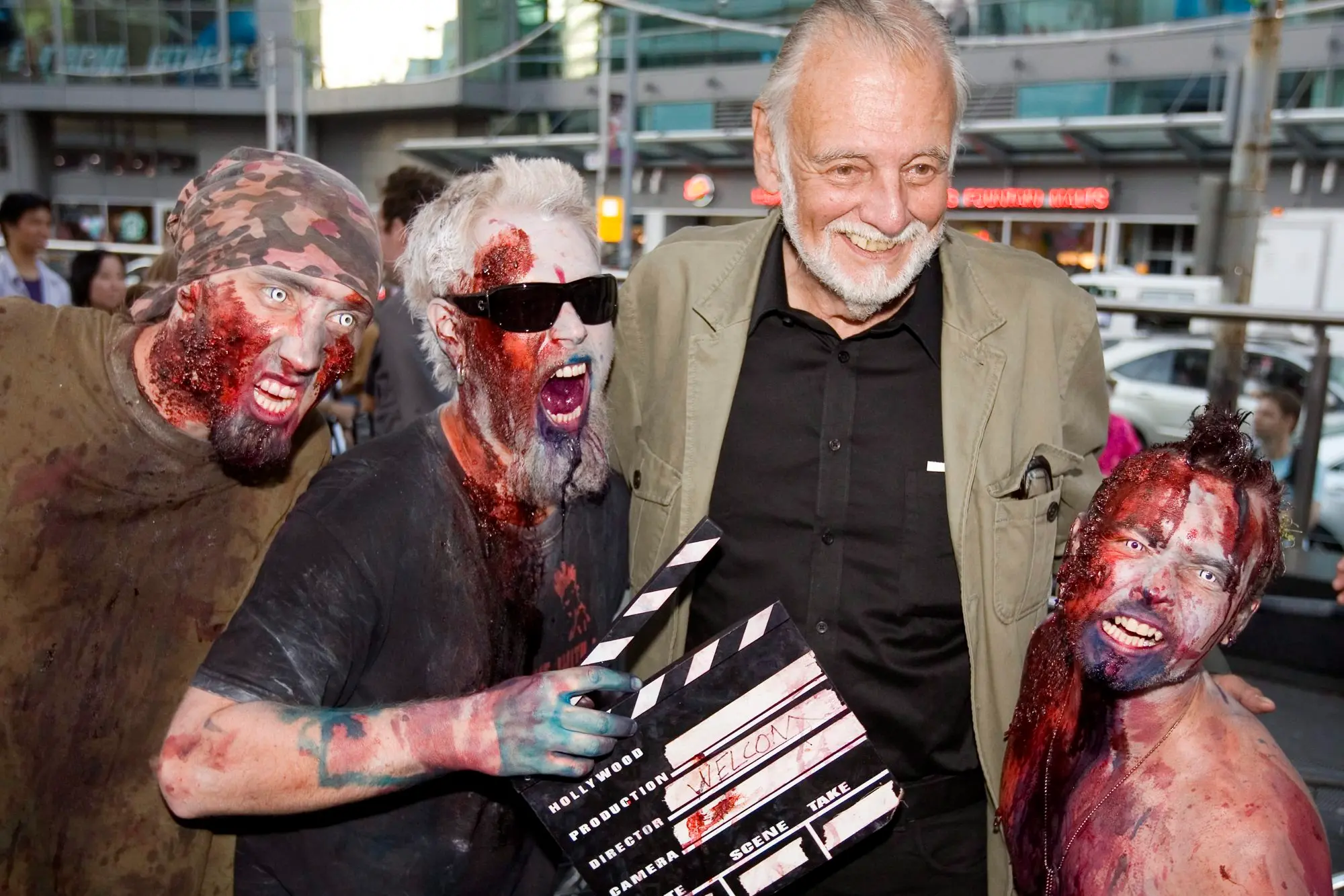 George Romero con alcuni fan vestiti da zombi